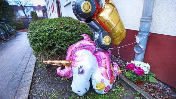 Ort des Abschieds: Trauernde haben zwei Luftballons - einen Laster f&uuml;r den Jungen und Einhorn f&uuml;r das M&auml;dchen - sowie Blumen vor dem Haus abgestellt. - &copy; Sarah Jonek