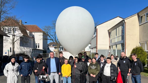Der Ballon ist gefüllt, gleich geht's ab in den Himmel: Die Verantwortlichen vom zdi-Zentrum Lippe.MINT und von der Stratoflights GmbH & Co. KG mit den Schülerinnen und Schülern. - © Lippe Bildung