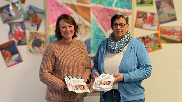 Einen Stapel von Broschüren überreicht Vanessa Mohnke (links) an die Leiterin der Marianne-Frostig-Kindertagesstätte der Lebenshilfe Detmold, Marina Wiegand. - © EUTB