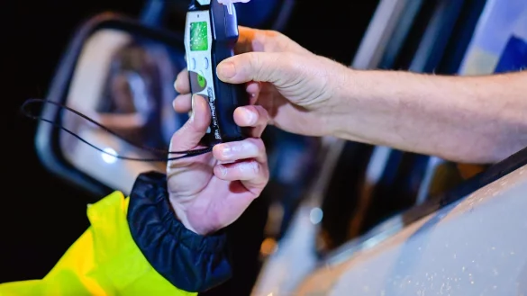 Ein Polizist reicht einem Fahrer ein Alkoholmessger&auml;t. - &copy; DPA