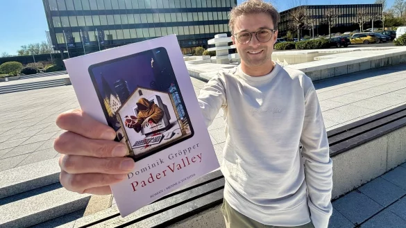 Dominik Gr&ouml;pper zeigt seinen Roman "Pader Valley" vor der fr&uuml;heren Nixdorf-Zentrale an der Paderborner F&uuml;rstenallee. Dort ist heute das Heinz-Nixdorf-Museumsforum untergebracht. - &copy; Jens Reddeker