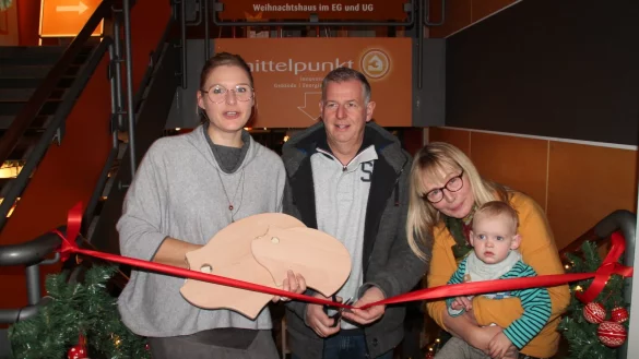 Jochen Dubbert duchschneidet das rote Band, w&auml;hrend Rabea Kruel (links) das &bdquo;Spendenschwein-Brettchen" und Claudia Beckmeier den kleinen Josse h&auml;lt. - &copy; Judith Stracke