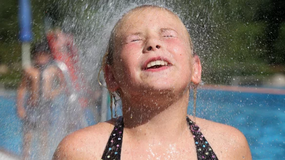 Im Schatten sind es gut 30 Grad, in der Sonne noch viel mehr. Die neunj&auml;hrige Kim genie&szlig;t die kalte Dusche im Freibad Heiden. - &copy; Bernhard Preu&szlig;