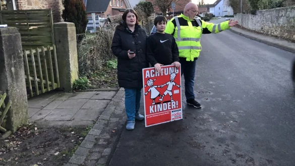 Carolin, Ben und Uwe Eschedor (von links) stehen vor ihrem Haus an der Dorfstra&szlig;e. Trotz der aufgestellten Blumenk&uuml;bel sind ihrer Beobachtung nach fast alle Autofahrer deutlich schneller als die erlaubten 30 km/h unterwegs. - &copy; Sven Kienscherf(LZ)