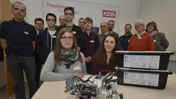 Stolze Erfinderinnen: Im Vordergrund freuen sich Doreen Schlue (links) und Malena Kania über ihren Roboter. Im Hintergrund (von links): Frank Schäl, Dieter Freitag, Lennart Schünemann, Thomas Lalk, Nils Hansmeier, Andreas Schell, Falco Baldig, Dr. Günter Uhlenbrok, Dennis Hoffmann, Marc-Oliver Hoffmann, Ingrid Müller und Gabriele Schmuck. - © Karl-Heinz Krull