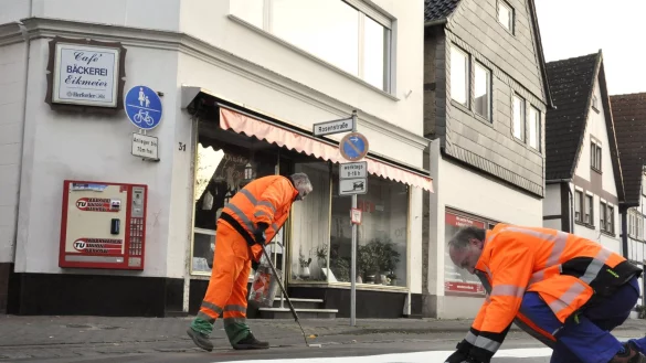Neuer Zebrastreifen: Frank Wollmuth (rechts) passt die weißen Platten für den Zebrastreifen an, während Burkhard Schnüll (links) von den Städtischen Betrieben den Kleber für den neuen Zebrastreifen an der Papenstraße, Ecke Rosenstraße aufbringt. Dieser soll ein sicheres Überqueren der vielbefahrenen Straße für alle Stadtbesucher ermöglichen. - © Watermann