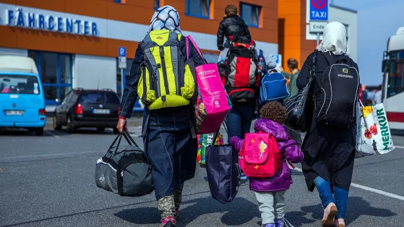 Eine Flüchtlingsfamilie geht am 14.09.2015 zum Fährcenter im Hafen von Rostock (Mecklenburg-Vorpommern). - © dpa