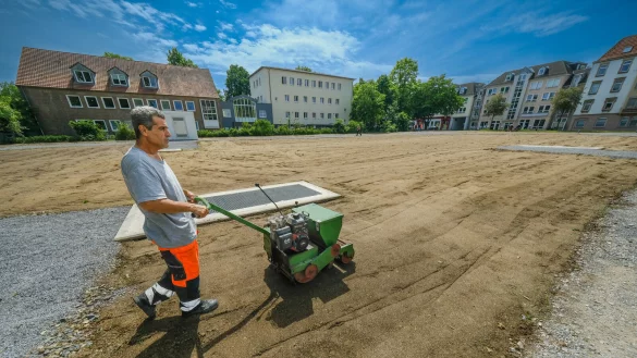 &Ouml;zden Embiya bearbeitet die Oberfl&auml;che. Im Untergrund befindet sich das 60 mal 40 Meter gro&szlig;e Regenr&uuml;ckhaltebecken. - &copy; Andreas Zobe