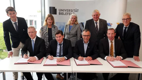 Wichtige Unterschrift: Rainer Norden (Aufsichtsratsvorsitzender des evangelischen Klinikums Bethel, vorne v. l.), Michael Ackermann (Geschäftsführer Klinikum Bielefeld), Gerhard Sagerer (Rektor der Universität Bielefeld) und Johannes Hütte (Geschäftsführer Klinikum Lippe) unterzeichnen die Kooperationsvereinbarung für das Universitätsklinikum OWL. Frank Lohkamp (Geschäftsführer der medizinischen Fakultät, hinten v. l.), Claudia Hornberg (Gründungsdekanin), Isabel Pfeiffer-Poensgen (NRW-Wissenschaftsministerin), Karl-Josef Laumann (NRW-Gesundheitsminister) und Stephan Becker (Kanzler der Universität Bielefeld) schauen ihnen dabei zu. - © Wolfgang Rudolf