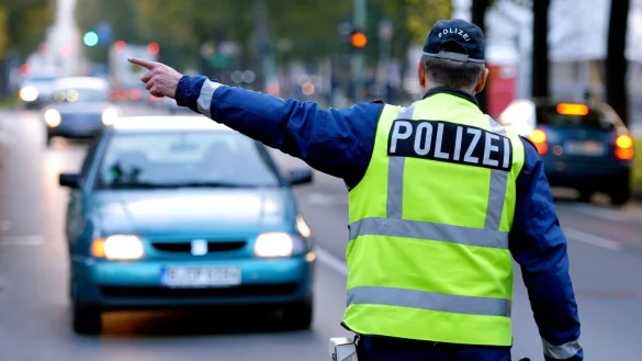 Ein Polizist stoppt ein Fahrzeug - &copy; Foto: Ralf Hirschberger/dpa-Zentralbild/dpa-tmn