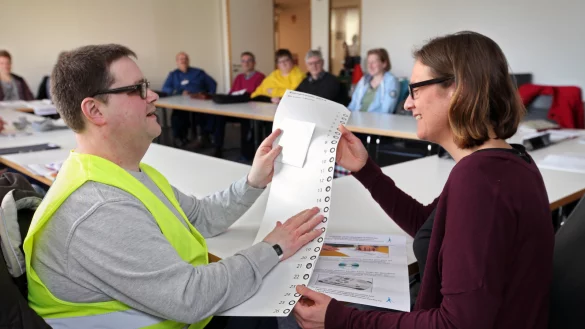 Gewusst wie: Stephanie Kleine von der Beratungsstelle schaut sich die Schablone und den Wahlzettel f&uuml;r Sehbehinderte an, den Sascha Mysliwecs zum Vorbereitungstreffen mitgebracht hat. Sehbehinderte k&ouml;nnen ertasten, wo sie ihr Kreuzchen machen wollen. - &copy; Bernhard Preu&szlig;