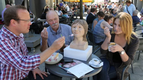 Freundlich, aber zurückhaltend: Kurator Simon Matzerath, Restaurator Eckehard Deichsel und Anastasia Sojanow, Auszubildende beim Landesverband, versuchen, die rekonstruierte Dame aus der Steinzeit mit Eis und Waffeln zu locken. - © Bernhard Preuß