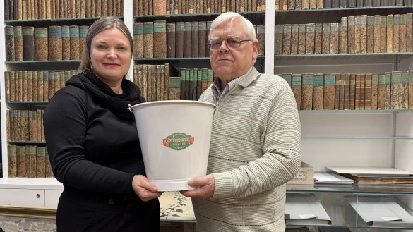 Sonja Beinlich und Fritz Gast suchen besondere Gegenst&auml;nde, die mit dem Zweiten Weltkrieg und/oder der folgenden Besatzungszeit durch die Briten zu tun haben. Der Eimer aus Stahlemaille ist eins der letzten St&uuml;cke, die aus dem Bestand der ehemaligen Haushaltswarenhandlung S. Obermeyer stammen. Die j&uuml;dische Familie wurde faktisch enteignet, viele Angeh&ouml;rige wurden von den Nazis ermordet. - &copy; Sven Kienscherf