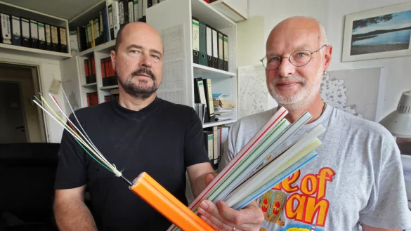 Breitbandausbau: Ulrich Stephanides (links) vom Kreis und Andr&eacute; Gronemeier von der Stadt Detmold koordinieren im Kreis Lippe den gef&ouml;rderten Breitbandausbau und halten Glasfaserkabel in die Kamera. - &copy; Bernhard Preu&szlig;
