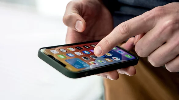 Ein Mann bedient ein iPhone - &copy; Foto: Zacharie Scheurer/dpa-tmn