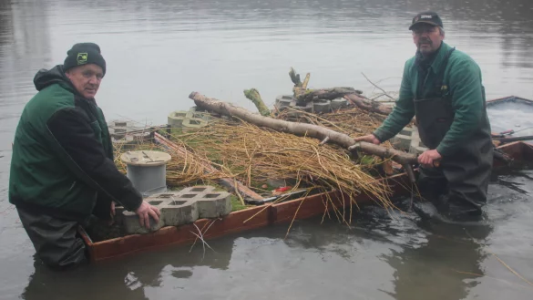 Detlef Lamprecht (links) und Lutz J&auml;nicke von der Firma Gerber Garten- und Landschaftsbau bringen die Inseln nach dem Stapellauf zu ihren Schwimmpl&auml;tzen, wo sie verankert werden. - &copy; Reinhold S&ouml;lter