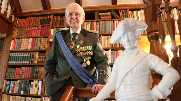 Geschichtsliebhaber: Otto Struck war 21 Jahre Oberst der Bad Salzufler Schützengesellschaft. Hier posiert er in seiner Uniform mit Friedrich dem Großen vor seinem Bücherregal. - © Yvonne Glandien