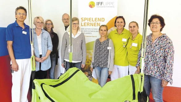 (von links) Dr. Günther Golla, Ergotherapeutin Antonia Gerstenberg, Motopädin Christiane Richter-Teles, Professor Thomas Brune, die Kinder- und Jugendpsychologinnen Tabea Brakhage und Agnieszka Wieler, die Physiotherapeutinnen Sandra Krause und Anna Kunze-Janzen sowie Marie-Luise Dresing, Pädagogische Leiterin des IFF. Die große grüne Schaukeltasche gehört zum Inventar des Therapieraums in der Röntgenstraße. - © Astrid Sewing