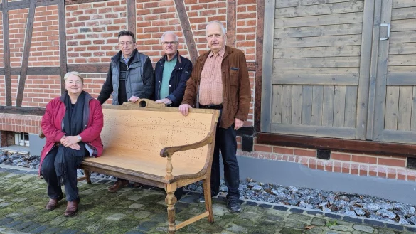 Petra D&uuml;e hat auf der alten Bank Platz genommen, die aufwendig restauriert wurde. Dirk Schneider (von links), Paul Fait und Hans-J&uuml;rgen von Boehn freuen sich, dass die alte Bank runderneuert zum Bahnhof Ehlenbruch zur&uuml;ckgekehrt ist. - &copy; Ana Adzovic