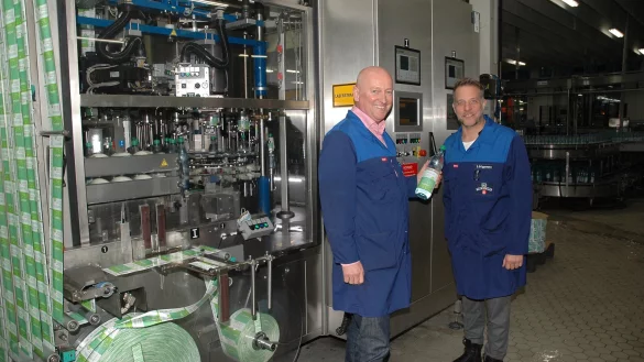Strahlen Zuversicht aus: Volker Schlingmann (links) und Stefan Brüggemann stehen in der großen Produktionshalle an der B 239 in Bad Meinberg vor einer Maschine, in der gerade Forstetal-600-Flaschen etikettiert werden. - © Manfred Brinkmeier
