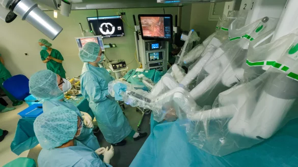 Die Arme des modernsten Da-Vinci-Operationssystems schweben über einem Patienten im neuen Operationssaal im Klinikum Bielefeld. Damit entfernt Chirurg Daniel Valdivia einen Tumor, der zwischen den Lungenflügeln gewachsen ist. - © Andreas Zobe