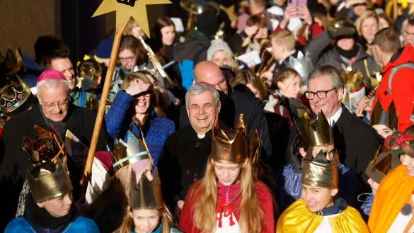 Erzbischof Udo Markus Bentz (M.) zieht begleitet von Weihbischof Matthias König (l.) und Bürgermeister Michael Dreier (r.) mit Sternsingern nach dem Gottesdienst vom Paderborner Dom durch die Stadt. - © epd
