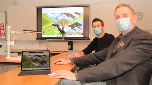 Der alte Tageslichtprojektor (ganz hinten) hat ausgedient und wurde nur f&uuml;r das Foto vom Dachboden geholt. Christoph Ullrich (links) und Eike Stiller setzen statt dessen im Unterricht auf die neue Technik, das IPad. - &copy; Carolin Brokmann