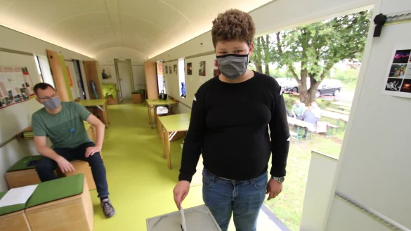 Wie bei den Gro&szlig;en l&auml;uft die Wahl im Jugendwaggon. Der 13-J&auml;hrige Justin wirft seinen Stimmzettel ein. Im Hintergrund: &bdquo;Wahlhelfer" Jochen Brunsiek von der Landeseisenbahn. - &copy; Jens Rademacher