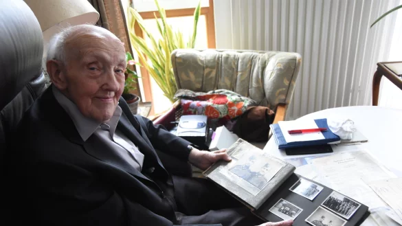 Der gebürtige Lagenser Hans-Joachim Schlichting durchblättert ein altes Fotoalbum, das seine Zeit als Soldat in der Wehrmacht dokumentiert. Aus Überzeugung handelte Schlichting dabei nicht. - © Raphael Bartling