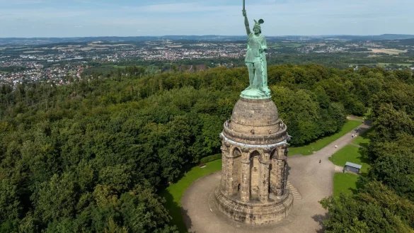 Blick auf das Hermannsdenkmal, Deutschlands größte Statue, in den Höhen des Teutoburger Waldes. Mehr als eine halbe Millionen Menschen besuchen den Ort jährlich. Am 16. August feiert der zuständige Landesverband Lippe den 150. Geburtstag des Hermannsdenkmals (Architektonische Höhe: 53 Meter) mit einem großen Familienfest. (Luftbild mit einer Drohne) (zu dpa: «Mythos und Geschichte: Das Hermannsdenkmal wird 150») - © Friso Gentsch/dpa