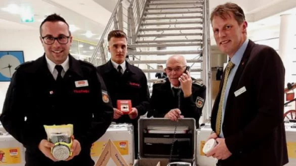 Den Notfallkoffer pr&auml;sentieren (von links) Tristan Krieger vom NRW-Verband der Feuerwehren, Giuliano Merola (Feuerwehr), Kreisbrandmeister Karl-Heinz Brakemeier und Jens Klusmeier (LLB). - &copy; Julia Kube