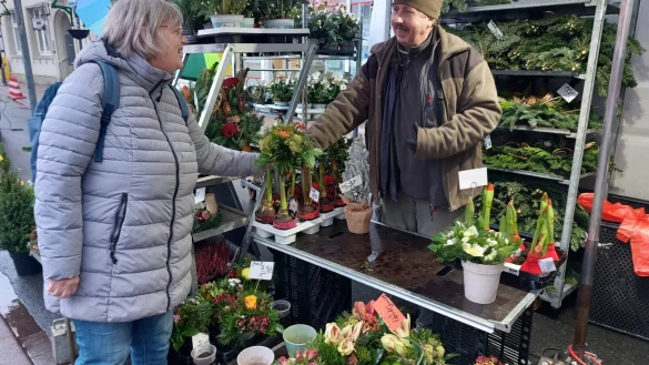 Ingrid Tappe kauft bei Blumenhändler Volker Gebert einen Blumenstrauß. Der Emmerthaler ist seit Mitte September mit seinem Stand auf dem Blomberger Wochenmarkt vertreten. - © Michaela Weiße