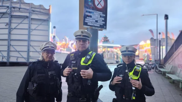 Polizeihauptkommissar Jens Solomon zeigt mit Polizeihauptkommissarin Sandra Niemeier (links) und Polizeikommissarin Sabrina Sundermann eines der Plakate kurz nach der Bahnhofsunterführung am Kronenplatz. 30 davon hängen nun im gesamten Stadtgebiet. - © Janet König