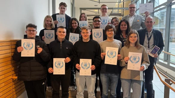 Die Lehrkräfte Ina Rinne, Schulleiter Heiko Jucks und Michael Lohre (von links) mit den Schülern des Hanse-Berufskollegs, die an der Model United Nations teilgenommen haben. - © Hanse-Berufskolleg