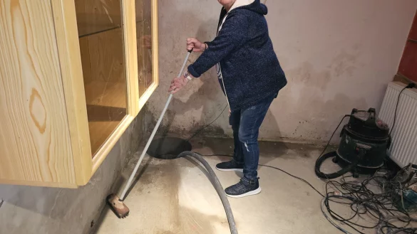 Annegret Wiese geht mehrmals am Tag in den Keller und greift zum Schrubber, damit das Wasser schneller in den Schacht läuft und nicht mehr Schäden anrichtet. Die Pumpe im Schacht schaltet sich mehrmals am Tag ein - auch nachts. - © Astrid Sewing