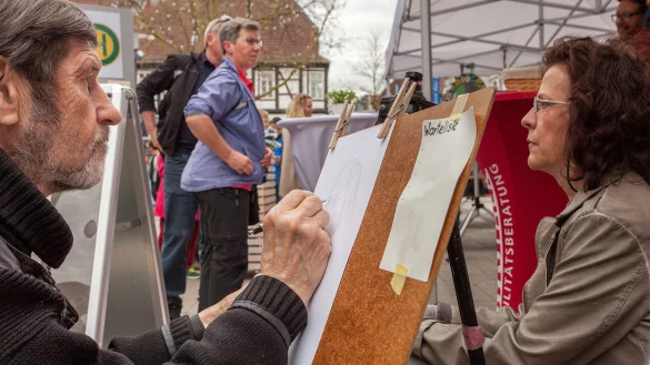 Konzentriert: Der Detmolder Maler Anatoli Netkal zeichnet Profilbilder von Besuchern. Dabei nimmt er sich Zeit, um jedes Detail aufs Papier zu bringen. - &copy; Torben Gocke