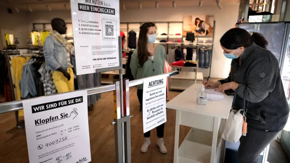 Eine Kundin shoppt in einem G&uuml;tersloher Modegesch&auml;ft. Dazu braucht sie mittlerweile einen Personalausweis und muss ein Formular ausf&uuml;llen. Auf diese Weise k&ouml;nnen im Fall einer Infektion ihre Kontaktpersonen nachverfolgt werden. - &copy; Andreas Fr&uuml;cht