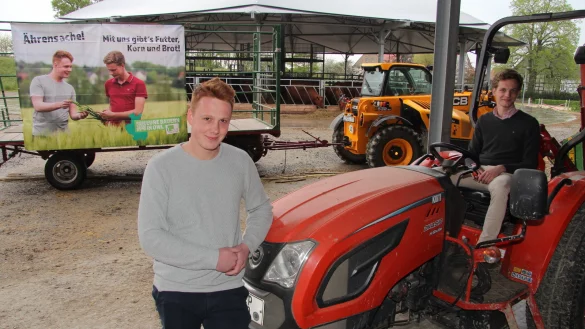 Die Junglandwirte Daniel Walgern (links) und Norman Middeke zeigen ihre Plakat. Im Hintergrund sind die Angus-Rinder vom Hof Frob&ouml;se in Pottenhausen zu sehen. - &copy; Nadine Uphoff
