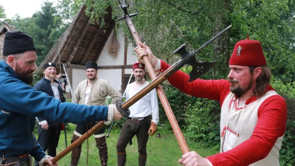 Schaukampf: Meik Te&szlig;mer (l.) und Tim S&uuml;dholter-Trantow (r.) beherrschen nicht nur die Hellebarden, sondern auch noch acht weitere Waffengattungen. Die anderen Mitglieder von &bdquo;DreyWunder", Henrik Gyarmati, Martin Prei&szlig;ler und Martin L&uuml;mkemann (hinten, v. l.), verfolgen das Geschehen. - &copy; Knut Dinter