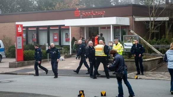 W&auml;hrend sich am Eingang Rettungsassistenten um die verletzten und geschockten Opfer k&uuml;mmern, nehmen die Polizeibeamten die Spuren auf der Stra&szlig;e auf. Eine der Pistolen liegt hinten am Bordstein. - &copy; Christian Mathiesen