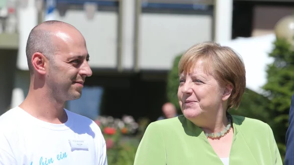 Altenpfleger Ferdi Cebi und Kanzlerin Angela Merkel vor dem St. Johannisstift in Paderborn. - &copy; Andreas Zobe