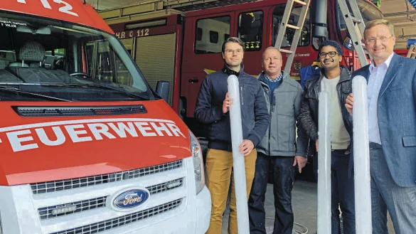 Roman Marks (Geb&auml;udemanager, von links), J&ouml;rg Diekmann (Leiter der Freiwilligen Feuerwehr Augustdorf), Lamine Traor&eacute; (Klimaschutzmanager) und Dr. Andreas J. Wulf (B&uuml;rgermeister) mit den neuen Leuchtr&ouml;hren. Foto: Gemeinde Augustdorf - &copy; Gemeinde Augustdorf