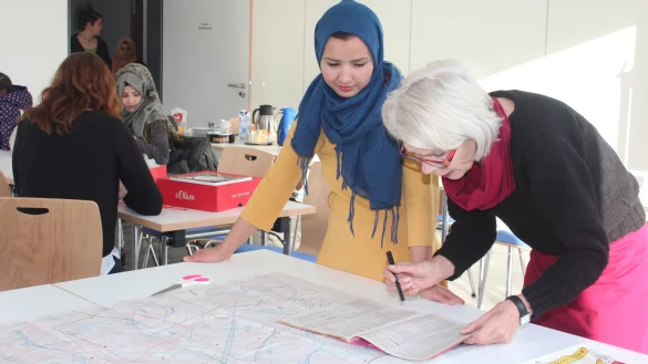 Zwei Frauen, ein Mantel: Bevor das w&auml;rmende Kleidungsst&uuml;ck entsteht, muss auf dem Schnittmusterbogen erst einmal der Kurs zur richtigen Kleidergr&ouml;&szlig;e gefunden werden. - &copy; Christine Reuner