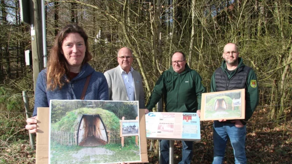 Kathrin Hunstig-Bockholt von der Lokalen Aktionsgruppe Senne³ e.V. zeigt auf dem Foto, wie der Schau-Kohlenmeiler aussehen soll. Im Hintergrund Bürgermeister Marcus Püster, Jens Geise, Vorsitzender der Kohlstädter Schützen, und sein Stellvertreter Nico Hanselle. - © Dieter Asbrock