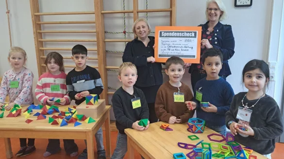 Stellvertretende Kita-Leiterin Margarita Wiebe (hinten links) freut sich mit den Kindern über die Förderung der Osthushenrich-Stiftung, überreicht durch Geschäftsführerin Claudia Holle. - © Stadt Lemgo