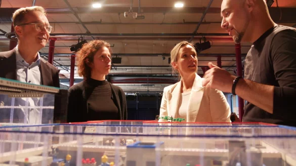 Günter Korder (v. l.), Rebecca Steinhage, Kirsten Thommes und Roman Dumitrescu sprechen über den KI-Einsatz in OWL über einem Modell, das Einsatzmöglichkeiten zeigt. - © Jemima Wittig