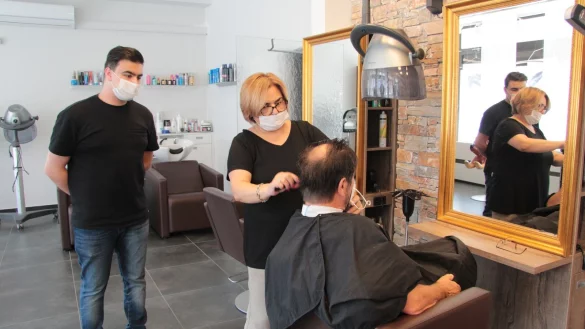 Friseur-Azubi Mourad Alkhalaf ist gerade ins zweite Lehrjahr gekommen. Seiner Chefin Nadide Sayan schaut er beim Haareschneiden &uuml;ber die Schulter. - &copy; Silke Buhrmester