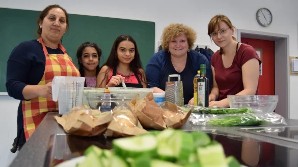 Gemeinsam gelingt die Gurkensuppe: (von links) Anna Sabokinova, Marie, Valya (alle Teilnehmer), Anne-Kathrin Edler (Komm. Integrationszentrum) und Caroline Giesler (Stadt HBM) schnippeln fleißig mit beim Kochtreff. - © Greta Wiedemeier