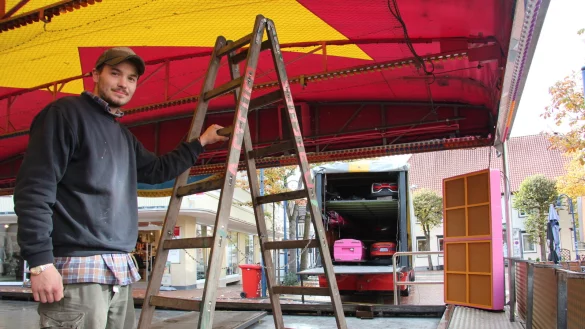 Maximilian Steuer baut den Autoscouter auf, der mitten auf dem Marktplatz steht. Drumherum gruppieren sich Marktst&auml;nde. - &copy; Cordula Gr&ouml;ne