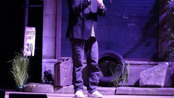 Reine Dystopie auf der Lemgoer Bühne: Paul Panzer zwischen Altreifen, Tankstellenschildern, maroden Häusern und einem kleinen Hauch von Gras. - © Axel Bürger